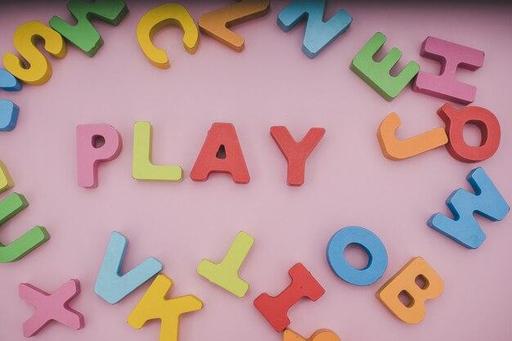 alphabet letters in various colors that spell the word play with other letters scattered randomly.