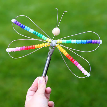 a wire whisk craft turned into a dragonfly type object with colored beads to create the wings